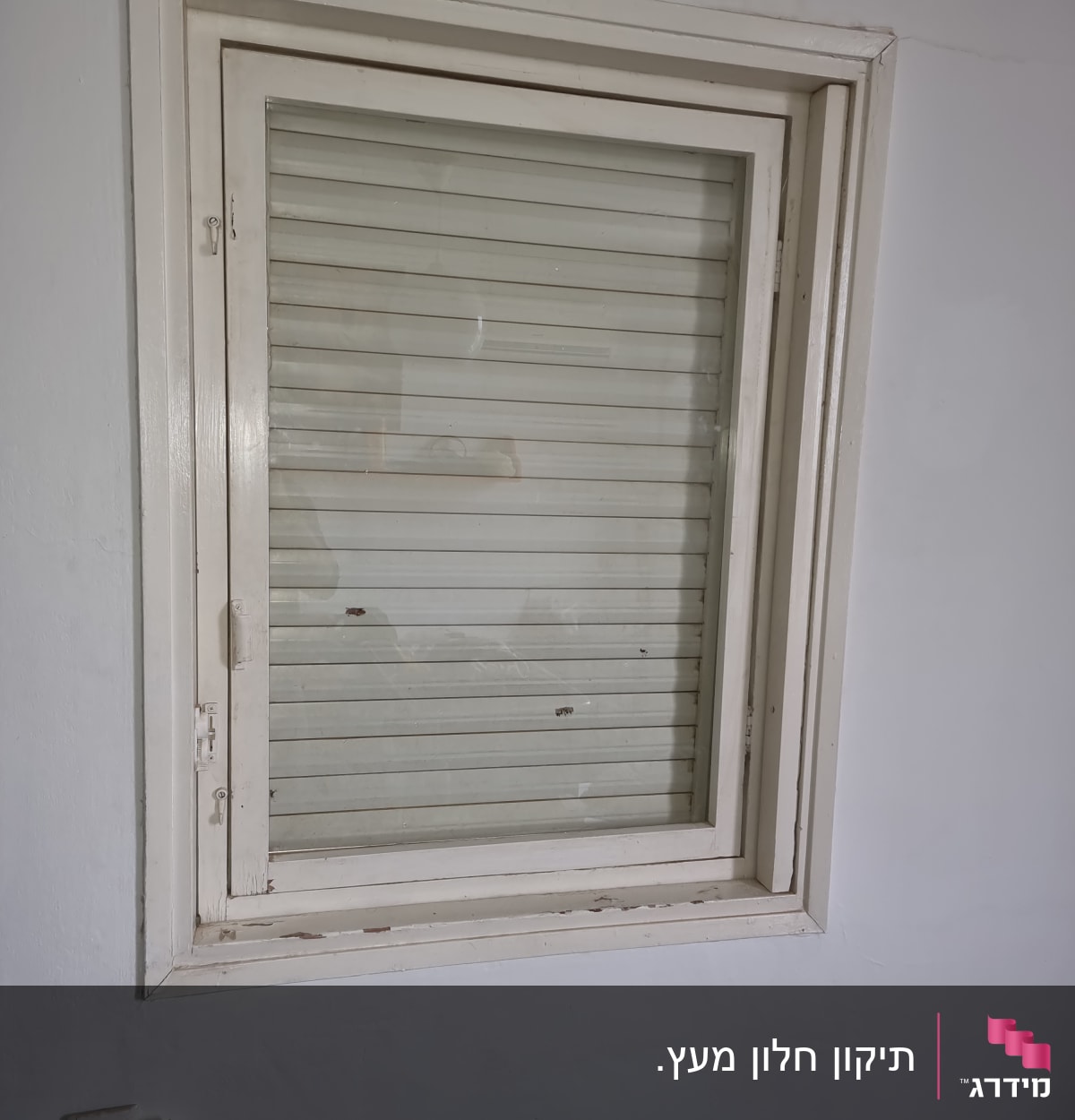 חלון זכוכית עם תריסים סגורים במסגרת לבנה